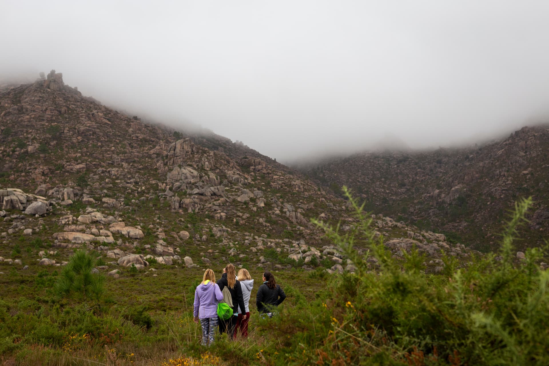 Grupo de senderistas en el entorno de O Pindo, Carnota, con la montaña y la niebla de fondo